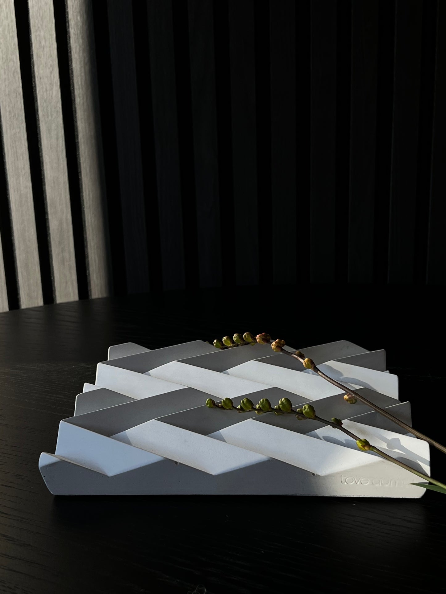 Ett fat från Tove Adman inspirerat av origamivikning. Reliefen gör att exempelvis frukt håller sig bättre pga luft underifrån. Dekorativt fat. Vit keramik.